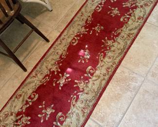 Red floral wool runner rug with tan scroll border