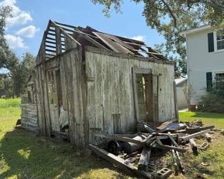 Weathered wood shed with collapsed tin roof and shutters