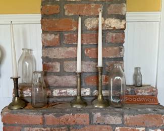 Brass taper candlesticks with vintage glass milk bottles, mantel display