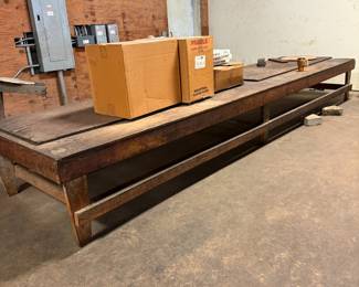 Long wooden industrial workbench with lower shelf