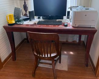 Wood writing desk with wooden slat-back chair and office setup
