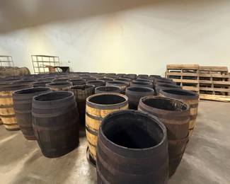 Large wooden whiskey barrels with metal bands, huge lot
