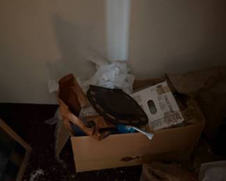 Box of miscellaneous items with tools and packaging