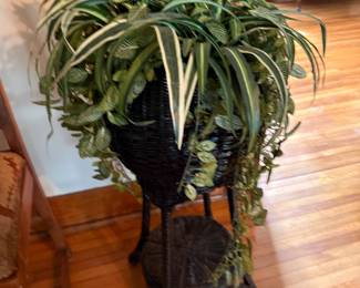 Black wicker plant stand with faux greenery arrangement