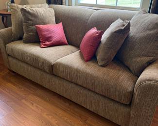 Brown chenille upholstered sofa with accent throw pillows