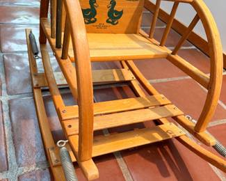 It’s a vintage “The Teetertot” bentwood child’s spring rocker/bouncer, manufactured by The Delphos Bending Co. of Delphos, Ohio. These were produced in various forms from roughly 1945–1979, and examples with the duck graphics are associated with the mid-century period