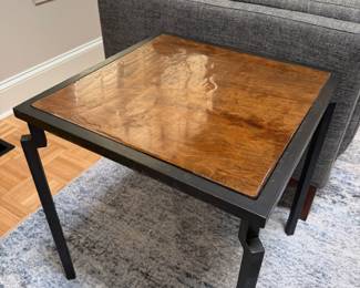 F10 - $200. PAIR of heavy metal framed side tables by Robert Augstell. . Wooden tops have uneven lacquer finish. Measures  20" square x 22.5" tall. 