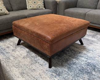 F8 - $125. Distressed Faux Leather Storage Ottoman. Top lifts to store blankets or remotes. Measures 36" square x 18" tall. 