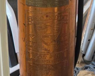 vintage Red Star Model 303 copper and brass fire extinguisher, manufactured by the General Fire Truck Corporation around the 1920s to 1930s.