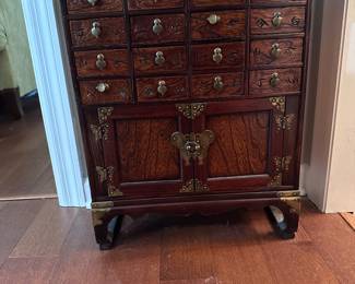 KOREAN APOTHECARY / MEDICINE CHEST  Traditional Yakjang-style Korean cabinet 16 individual drawers + lower storage cabinet Hardwood with brass fittings & butterfly hardware Hand-carved Asian characters on drawer fronts  26” H × 23.5” W × 9” D