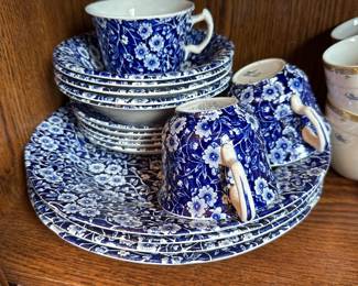 VINTAGE TRANSFERWARE SET Classic "Calico" Pattern — Made in England A charming vintage earthenware tableware set featuring the classic English "Calico" blue and white all-over floral pattern. Perfect as a decorative display set or to complete an existing collection.  SET INVENTORY (18 PIECES TOTAL) 4 Dinner Plates 5 Soup / Cereal Bowls 6 Saucers 3 Tea Cups *Note: Entire set sold together as-is. Two tea cups are in clean vintage condition; one tea cup exhibits heavy interior glaze crazing.