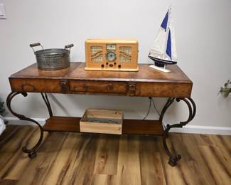 This vintage-style world map console table faux-luggage drawer fronts and ornate scroll iron legs