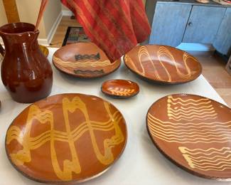 From left, redware pitcher by Foltz, $100; redware charger by Shooner, $120; small redware dish by Shooner (center), $45; redware dish by Woods, $100