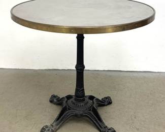 Lot 1762 French style circular bistro table with metal top and brass edge banding on ornate cast iron pedesta
