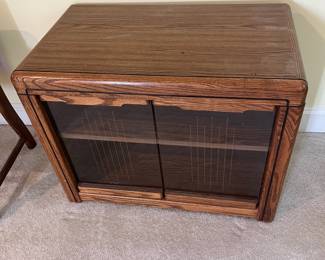 T47 - $10. Wood cabinet with glass doors and 1 adjustable shelf. Measures 28.5" x 16.5" x 22" tall. Good condition, but back needs to be reattached.