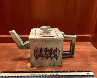 T25 - $25. Unsigned Pottery Teapot with Leaf Design. Measures 10" x 6" tall. Excellent condition.