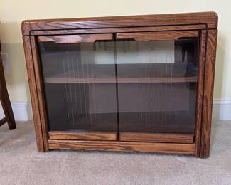 T47 - $10. Wood cabinet with glass doors and 1 adjustable shelf. Measures 28.5" x 16.5" x 22" tall. Good condition, but back needs to be reattached.