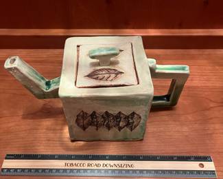 T25 - $25. Unsigned Pottery Teapot with Leaf Design. Measures 10" x 6" tall. Excellent condition.