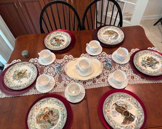 Dining room table and chairs available for sale. Set of red charger plates. Set of 8 coffee cups and saucers