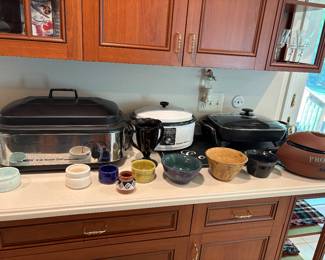 Several crock pots, including a football pot available for sale.