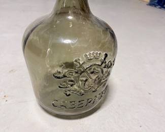 Tall decorative glass jug/bottle with crest emblem. $35