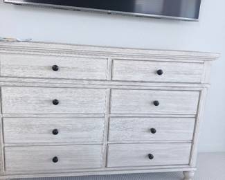 Oversized solid-wood dresser in distressed white, 8 drawers with black knobs. Coastal bedroom collection. $550