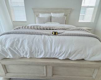 Queen bed frame in light distressed wood with oversized paneled headboard and footboard. Excellent condition. $550