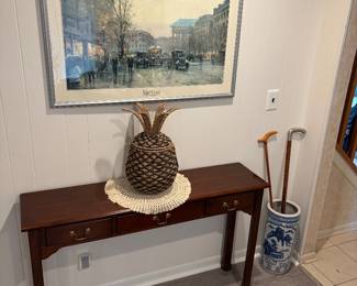 Two drawer sofa, table, nicely, framed artwork, wicker, Pineapple, ceramic umbrella, holder and pair of canes.