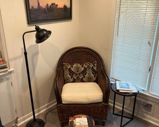 Wicker chair with Reading lamp nicely, framed artwork, and plant stands
