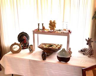 Ceramic turkey and giraffe, gold Christmas ornaments, candleholders, and ceramic artwork.
