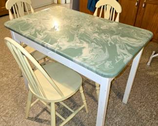 Vintage metal table with swirled, enamel, top features drawer and four wood chairs. 40" x 25" $125