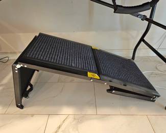 Adjustable, metal frame pet ramp with textured carpet surface.