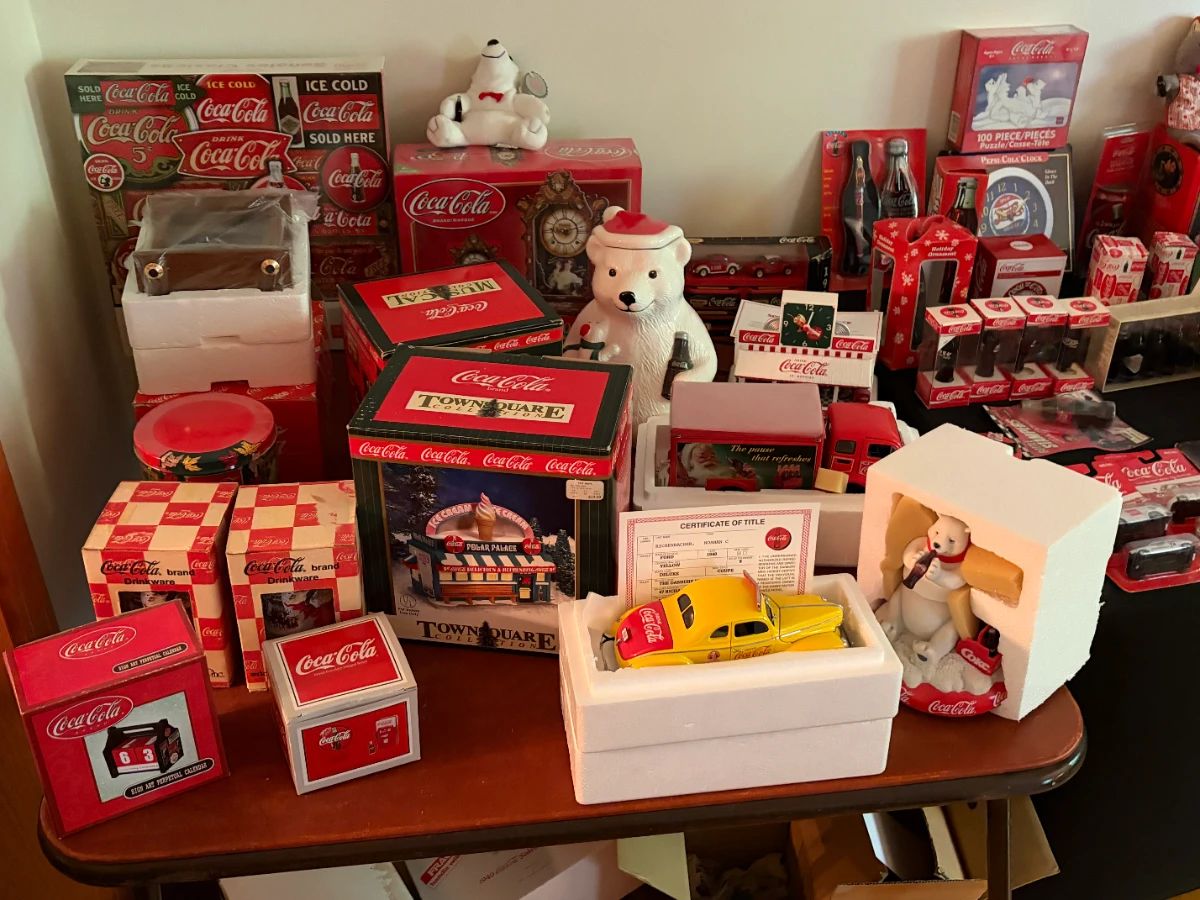 Vintage Coca-Cola collectibles including polar bear cookie jar, Town Square Collection Polar Palace, Danbury Mint 1940 Ford Coupe with certificate, polar bear figurine, delivery truck, drinkware and perpetual calendars
