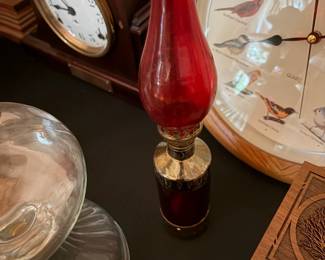 Ruby red glass oil lamp with vintage mantel clocks