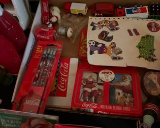 Assorted Coca-Cola tins, coasters and small collectibles