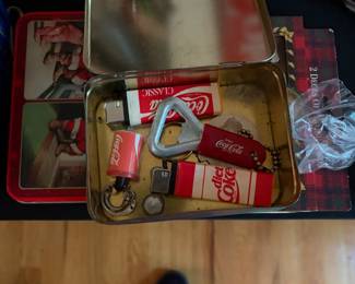 Coca-Cola tin filled with bottle openers and small collectibles