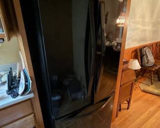Black Whirlpool French door refrigerator with bottom freezer