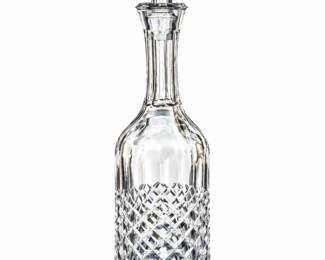 Slender cut-glass decanter with a long neck and tapered faceted stopper.