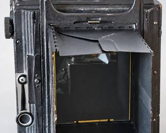 Vintage large-format camera with an open rear viewing hood and visible age and wear.