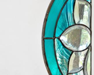 Turquoise and clear glass window hanging with geometric detailing.