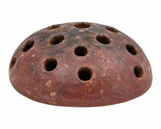 Brown pottery flower frog with a domed shape, multiple stem openings, and a mottled, worn finish.