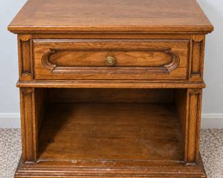 Wood nightstand with a carved drawer front, brass-tone knob, and roomy open lower shelf.