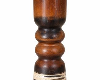 Sculptural brown vase with rounded contours, dark shading, and a cream-and-black patterned base.