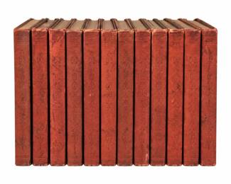 Collection of red-bound books with decorative spines.