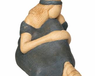 Seated female figurine with flowing hair and a dark dress.
