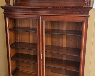 VICTORIAN BOOKCASE ◆ COLLECTIBLE DECANTERS  Carved wood bookcase with scrollwork crest, glass doors, display shelves, and lower drawers ◆ Germany, lion, elephant, football, Ohio, and donkey decanters.