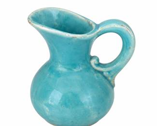 Small turquoise pitcher with a curved handle.
