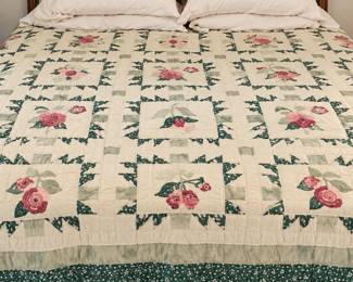 Wood bed with a paneled headboard and cream floral patchwork quilt. Headboard quilt, frame, pullows all sold separately.