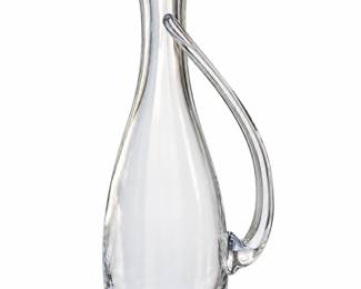 Tall clear glass pitcher with an angled rim and long curved handle.