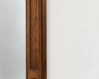 Wood-framed wall mirror with decorative recessed detailing.
